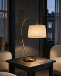 Calder Arc Table Lamp switched on in a charcoal living room