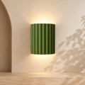 ArtiGlow Modern Resin Wall Light in green on a warm architectural interior wall