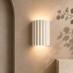 White ArtiGlow ribbed wall light on a warm taupe architectural wall